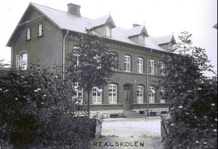 Realskolen. Jyllandsgade.
Det var ikke mig forundt, at komme på realskolen. Det var en hel verden for sig selv. Når man gik forbi skolen, kunne man tit høre eleverne  få undervisning. Jeg ved, der er gået mange elever på skolen, som jeg tit gik forbi. I dag er den væk, som det er gået så mange andre bygninger.
