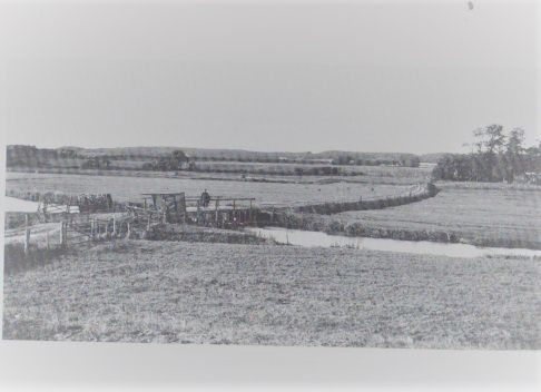 Kongeåen, med en lille bro, ca. 1920. Da Tyskerne var i krig mod Danmark savede de træbroen i stykker. så man ikke kunne komme over på den anden side. Der stod tyske soldater og holdt vagt. Man kan fornemme stien, der fører op til Skibelund krat. Meget store markvidder var der dengang. Et lille hus blev bygget der i 1870 kaldet Friheden, af en storbonde.Og huset ligger der endnu, i 2017.
Niels Hansen  Jacobsen, stenhuggeren fra Vejen, lavede Modersmålet, der står i Skibelund, og skuer ud mod det tabte land.
Det giver god mening med placeringen, når man ser dette billede. Der kunne man havde frit udsyn fra Skibelund til Kongeåen.