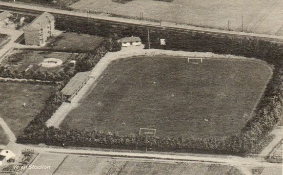 Vejen gamle fodboldstadion. 
Var utrolig godt besøgt i gamle dage. Der var mange Vejen borgere der valfartede der, når der blev spillet i 1950erne. 
 Dengang var der indgang til stadion fra Plantagevej. 
Når jeg ser på billedet i dag, tænker jeg, at man ikke var så forvendt, som i dag. Det gik man ikke så højt op i den gang.
Her er en film af en fodbold kamp. Linket kan Googles.

 https://filmcentralen.dk/museum/danmark-paa-film/klip/fodboldkamp-korsoer-vejen
