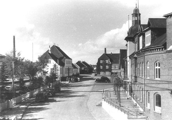 Banegårdspladsen i 1950erne var et omdrejningspunkt for mig. Jeg ved ikke hvorfor, det ser mere hyggeligt ud, end i dag.
Der var en helle midt i gaden dengang, nederst i venstre side. En meterhøj gul stander, man kunne stå ved, hvis der kom trafik til og fra Banegårdspladsen.
Jeg havde en isvinter været hos æggepakkeriet i Ahornsgade  og købt 20 æg. På hjemvejen, da jeg skulle ned gennem tunellen, mistede cyklen grebet på grund af isen, så jeg røg på hovedet med æggene. Så der var dømt æggekage den dag.