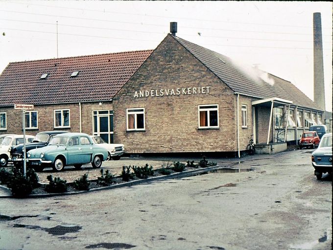  Arne Holm Pedersen.
Askov.
Hej Johs.

Hermed får du mit billede af vaskeriet, som jeg fotograferede i 1966. Det er det eneste billede, jeg har fundet af virksomheden. Igen fotograferede jeg vaskeriet, da det blev brudt ned for nogle år siden.
Med venlig hilsen.  Arne


Ved Møllevej  12  i Askov, startede Askov Andels vaskeri op. Cirka i 1912.  I starten hængte man lagnerne til tørre, på tørresnorene, udenfor. Man vaskede også for private.
I dag ligger det som en tomt,  som en forurenet grund, da der er chlorerede opløsningsmidler på det tidligere renseri.
Siden flyttede man vaskeriet til de tomme bygninger i Vestergade i Vejen, hvor der havde været Alfa Margarinefabrik.
I dag 2018 er der mange ansatte, på vaskeriet.
Indkørslen til Andelsvaskeriet, er idag en gade. Søndervangsvej.
