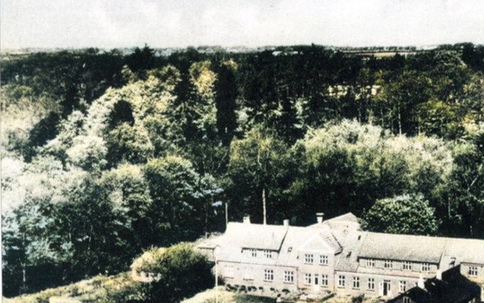 Når man går ud af Skibelund krat, bagom Skibelund Pavillon, gik man forbi Skibelund Efterskole,  stien helt til højre. Skolen var bygget helt op til Skibelund Krat.
Det er et ældre billede af Efterskolen, som jeg synes der skulle være lidt farver på.
 Kongeåvejen ligger uden for billedet, der var marker dengang. Så billedet må være fra 1935 eller ældre tid.
Efterskolen er  oprettet i 1874. Man startede ved det lille hus ved siden af Skibelund Pavillon.
Dette billede må være den første bygning. Der har over årene kommet flere bygninger til. Og i dag kan man ikke kende Efterskolen som den var engang.
I dens start var der marker op til skolen.