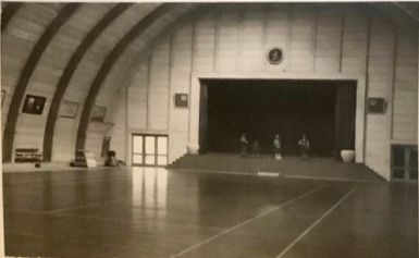 Ulla og Jørgen har sendt et dejlig billede af   teaterscenen i den gamle Vejen Hal. 
Sådan husker jeg Vejen Hallen da jeg startede med at spille Badminton  dernede. Med de to højtalere ved scenen og uret oppe over den.
Døren til højre var ud til omklædningsrummene og døren til venstre ud til Parkeringspladsen, og cyklerne ikke at forglemme.
Der var mange cykler på det tidspunkt i 1950erne.