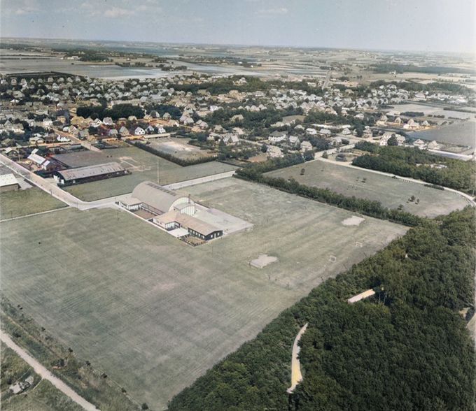 Et Vue over Vejen hallen Fuglesangsallé 10 fra 1953, og Fuglesangsalle der drejer ned ad Ahornsgade, med den sorte Phønix hal, der blev bygget i anledning af  Sydjysk Udstilling  i 1951.
    Og til venstre for den, Vejen Æg pakkeri der er rød, med reklamen på taget.  Dansk Andels Æg export.
Og Danmarksgade der er startet med Svømmebadet. Svømmebadet er ikke særlig tydelig på billedet, men må sikkert være der. Svømmebadet blev indviet den 8. juli 1951.  
Til højre for svømmebadet er det Østergade med den gule  bungalow. Bungalowen der var ejet af Hans Chr. Hansen   og Anna
Margrethe Hansen, Hansens Hotel, der  solgte huset til Politistation.         
Tilbage til Vejen hallen med fodboldsbanerne som de fleste på den tid sikkert har  spillet fodbold på, kan man se at der har været rigtigt meget aktivitet ved målene, hvor græsset er helt slidt af.
Til højre for Vejen hallen var der i mange år Tivoli til Troldefesterne. Efter Sydjysk Udstilling i 1951 begyndte Troldefesterne og Georginefesterne de følgende år, og Cirkus G.O.Gine  opstod med lokale kunstnere.
Og bag Phønix bygningen havde Cirkus Benneweis  tit deres cirkus stående.
I dag ligger Knudepunktet der, men det er en hel anden historie.