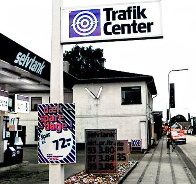 Texaco Trafik Center Nørregade 73-75. 1980.
Og til venstre for benzintanken er det fra 1938 Slagtersvend Frits Dahl til 1957 Slagtermester Frits Dall. Senere overtog 
Slagtermester Ib Sandfeldt  butikken Nørregade 77.
Jeg har været lidt på vildveje med det jeg troede var et ur med store ur visere på muren, men har fundet ud af at det er to lys neonrør.