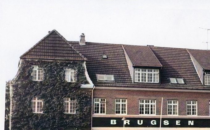 Vejen Brugsforening fra 1913, Banegårdspladsen 3, Vejen uden år. Postkort.
Vejen nye Brugsforening opført i 1913 efter den gamle brugsforenings brand. Arkitekten var Niels Ebbesen Grue 1879-1937  der også tegnede Brugsforeningen i Askov.
 Et nyere billede af Brugsforeningen, hvor man kan se vinen på muren til venstre.
Der er blevet bygget om kan man se hvis man kigger på billedet under dette.
Det er sådan jeg husker Brugsforeningen.
 Som administrationsbygning for Tagpap fabrikken Phønix opført i 1967, nedrev man Brugsforeningen og byggede administrationsbygningen, heldigvis i røde mursten.
Karl Knudsen.
Godmorgen Johannes - sikke en byggestil dengang - rigtig nok noget andet end nutidens hæslige beton kasser.
Erik Schlünssen.
Erindrer Man underholdningen a' 
