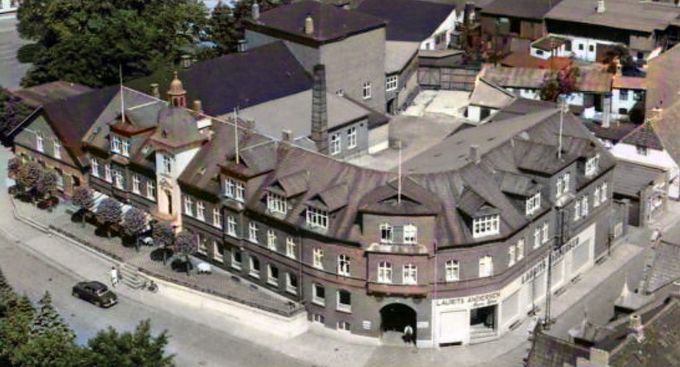 Hansens Hotel. Også kaldet Vejen Stationskro.
Hotelejer H. C. Hansen 1858-1924.
Den 3. oktober 1874 åbnedes Jernbanen tværbanen, gennem Vejen.
I september 1911 indviedes den nye fantastiske teaterscene i
tilknytning til den gamle dansesal fra 1877.
I 1904 byggede man Hansens hotel til, som den ser ud i dag.
Dog uden teatersalen som man fjernede i 1988. Der har været utrolig meget i teatersalen, mærkeligt at man ikke bevarede den.
Den sidste renovering af hotellet kom i gang i 1990.
Det havde jeg ikke lige tænkt på. Manufakturhandler Laurits Andersens forretning var en del af Hansens hotel.
Vejen by startede ved Vejen Gæstgivergaard,
og det var først da byen fik Togestationen og starten på Hansens Hotel, at der blev bygget i syd. Dengang var der ikke forretninger eller gader mellem Nord og Syd. Det kom lidt efter lidt at byen blev sammenhængende.
Mona Schmitt Vestergaard.
Mange gode minder. Rejsefilm med Jørgen Bitsch , koncert med orkester fra Vejle samt præsentation af instrumenterne for os skoleelever. Skolefester, baller og jazzklub i de glade 50ere.