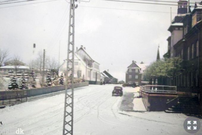 Et idyllisk vinterbillede fra viadukten op til Banegårdspladsen.
Karl Knudsen.
Godmorgen Johannes - et dejligt billede, lige som jeg husker det fra min barndom, og at dømme efter bilparken, må det være taget lige efter krigen.
Karl Knudsen. Godmorgen Karl. Ja det er et ældre billede fra fyrrene. Det var dengang Vejen var idyllisk. I dag har jeg ikke fundet et ord for hvad den er i dag. Ja det er sikkert Jens Skovs taxi den ene.