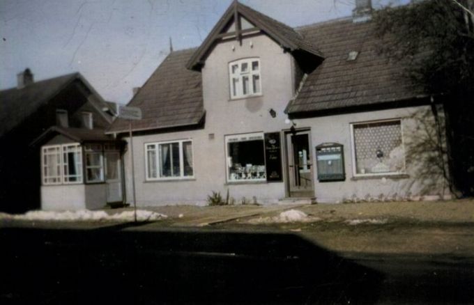 BENT ULSTED OLESEN.
Fandt disse billeder af Katrine Schmidt´s tobakshandel og min fars frisørsalon, på det der i dag hedder Vejenvej 17 i Askov . Som mange andre havde fru Schmidt også en automat udenfor. Lukkeloven dengang var meget streng, så efter klokken 17.30 på hverdage fredag 20.00 lørdag kl.14.00 og søndag lukket, var det ikke muligt at handle. Så kunne man forsyne sig med slik og tobak fra automaterne. Bagerne var de eneste der måtte holde åben om søndagen.