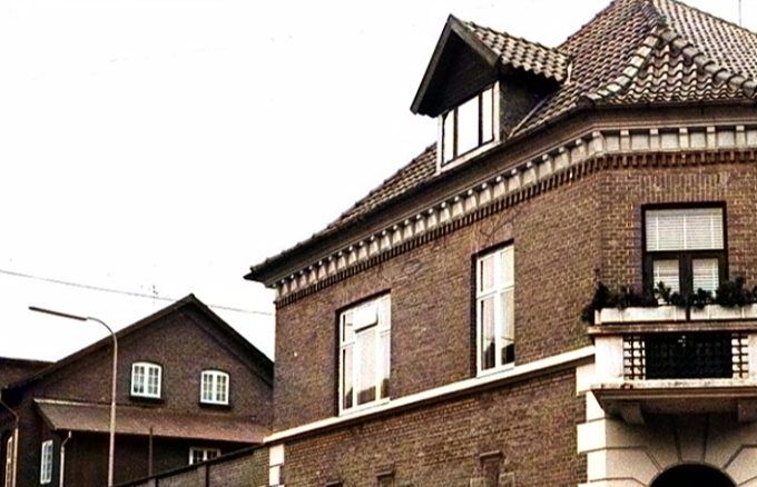 Et nyt farvet billede af Sparekassen på hjørnet af Søndergade og Jyllandsgade.
Det er måske det flotteste billede jeg har set af Sparekassen.
Til venstre ser man Vejen realskole. Men det lille hus der støder op til Sparekassen til venstre ved jeg ikke hvad er.
Vejen Sparekasse blev oprettet 1867. Og i 1911 blev Sparekassen bygget. Efter Sparekassen kom Inger og Hans Kiilerich, Jysk Tricotage der ombyggede Sparekassen, hvor de var fra 1969 - 1996.
Marianne Lautrup.
Ja det er et flot billede. I den flade bygning til venstre, var der, da jeg boede der, garage og mødelokale til sparekassen. Ovenpå havde vi terrasse.