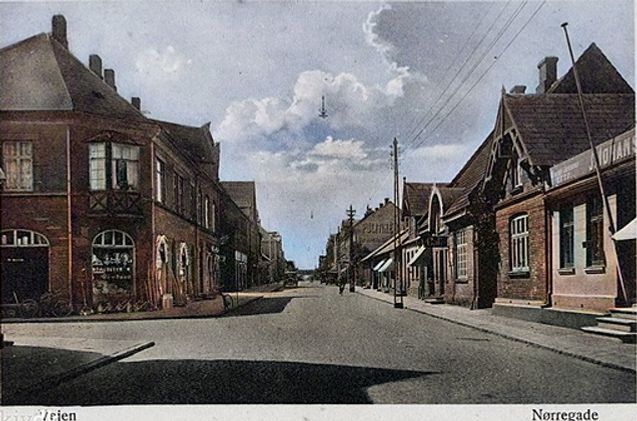 Postkort af Nørregade i Vejen. Set mod syd fra Nørregade 26, Kastens Isenkram. Huset opførtes i  1909 - 1960  af Arkitekten  Niels Ebbesen Grue. 
Til højre   må det være Sadelmager J. Johansen Lund & Søn Tapetserer.
Og til højre for sadelmageren 1931-1970  Villes Konditori, og til højre for Cafeen   nr. 17  Aktuelt.
Så kommer Fiskehandler Krintel og Gartner Bills butik. Så må det være Bager Sørensens butik, med den store gavl. Dengang var der næsten altid malet reklamer på gavlene.  
På en gang blev højre side fra Hansens Hotel forbi Skovvejen og Noras tobaksbutik til Bills blomsterbutik og Fiskehandler Krintel nedrevet i 1970erne. Den sidste butik der slap var Tage Henriksen Antikviteter,    Nørregade 25.