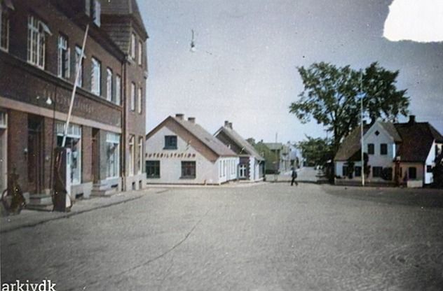 Til venstre er det den gamle Brugsforening.
Ja der var ro på i 1940erne.
Og ved siden af starten på Vesteralle, den gamle rutebilstation der var grømalet da jeg startede mine ture derned i 1950erne.
Så er det et flot syn af Jernbanegade, og til højre i billedet er det August Klockmann`s  dengang idylliske hus.
Birthe Klockmann som jeg gik i skole med i Bakkely fra 1953 skriver. Birthe Klockmann Nielsen.
Min far overtog sin fars  I. H. Klockmann`s vognmandsforretning i 1933.
Det er lidt mærkeligt at tænke på at det hele er væk i dag,  2022.
Hvis man skulle skrive en bog om det gamle Vejen kunne den hedde, Historien der forsvandt.