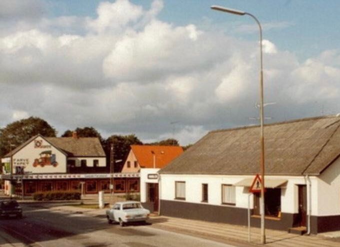 Et nyt billede af huset til venstre for Vejen kirke.
Baggårdens Møbler, Nørregade 100.
Vejen ny kirke blev indviet i 1896. Og overfor er det Kirkegården.
Forretningen helt til venstre var Ide Centret hvor man bl.a. meget andet kunne købe tapet og maling.
Der har været mange ting i den butik.
Fra 1938 var der Købmandsbutik. Startende med Jens P. Simonsen til 1957 Købmand Gunnar Nielsen.
Cirka i 1979 var der så Ide Centret. Så har der været Kæledyrsshoppen og i dag 2022 er det Vejen Gardens Genbrug.
Bertha Kirstine Christiansen.
Baggårdens møbelhandler hed Jens Erik Jensen. Søn af pottemager Jensen og fru Jensen, der var syerske. De boede med indkørsel fra Nørregade, i gården bag møbelforretningen.
Senere solgte Jens Erik og hans kone forretningen , flyttede til Langeland, hvor de drev en campingplads.