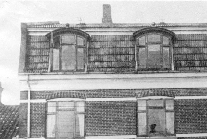 Beskrivelse.
Nørregade 3 i Vejen, omk. 1920. I huset lå Eduard Nielsens Boghandel og Valdemar Grunnets urmager forretning.
Bemærkning. Bygningen tilhørte oprindelig sodavandsfabrikant Andersen, der havde sit kulsyre apparat og øl lager i kælderen til højre på billedet, der kan tidsfæstes til 1905-1910. Andersen boede med sin familie på anden sal. I huset der skimtes til venstre boede en smed Birk og senere sadelmager Lund. Edvard Nielsens forretning flyttede ind i Nørregade 5 og atter en gang tilbage til nr. 3 og til sidst omkring 1916 til kosmorama bygningen. Urmager Grunnet flyttede til nr. 9 og blev erstattet af cigarmager D. Holm. I boghandelen blev der senere etableret en hatteforretning Melbye og senere Sackmann.