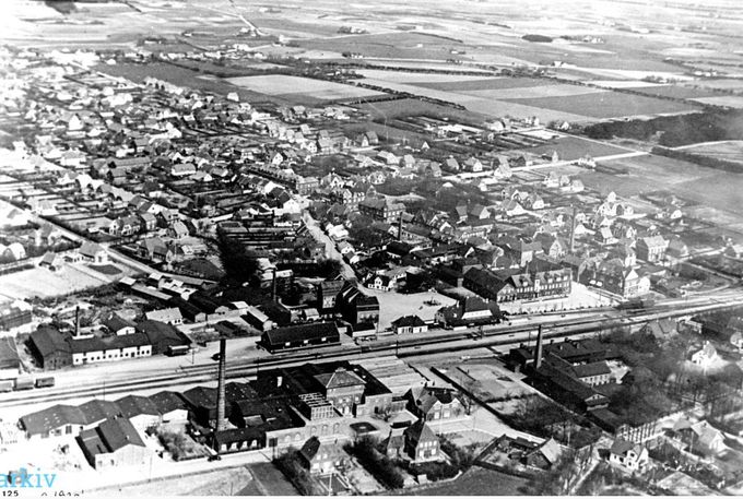 Luftfoto af Vejen Stationsby omkring 1930.
,,,,,,,
Et utrolig flot billede af det gamle Vejen, inden man begyndte at nedbryde den. Det er som et helt puslespil at gå det hele igennem.
Nederst på fotoet er det Jernbanen og Vestergade med Alfa Margarinefabrik.
På den anden side af jernbanen er Banegårdspladsen med Johannes Lauridsen buste. Og op i billedet Jernbanegade, der udmunder i Nørregade, ved Grunnet Lauridsens Varehus der blev drevet af Valborg Lauridsen, hvor Vejens første Apotek også har været.
Der er flere skorstene, for neden er det Alfa Margarinefabrik, og Phønix Tagpapfabrik til venstre, og til højre Nørrejylland Cikoriefabrik. Nederst til højre går Jyllandsgade op til Vestergade, med stien op til gården Grønvang.
Og huset med gavlen som er til salg i dag. Det er et hus der rummer meget historie.
På den anden side af skinnerne er det til højre Vejen Mejeri  skorsten, og til venstre for det Bager Sørensens Skorsten.
Ja det er 20 år før at Vejen hallen og Vejen Svømmebad kom på tegnebrættet.  
Der er mange ting på billedet man kan hæfte sig ved. Fuglesangsalle er der heller ikke tænkt på endnu. 
Oppe til højre er det det store anlæg med søen. Det er nok starten på anlægget man ser.