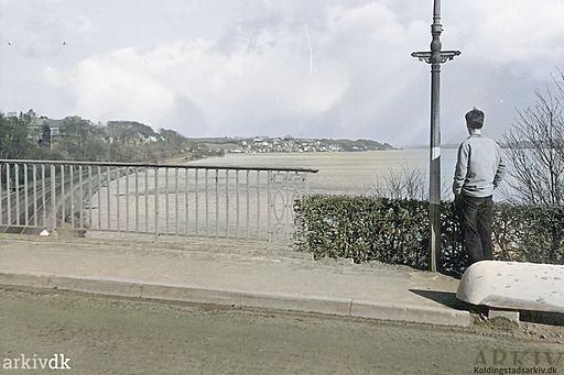 Svineryggen.
Kolding. Ndr. Havnevej. Udsigt ud over fjorden mod Strandhuse fra den første bro over jernbanen, der blev kaldt Svineryggen, som forbandt Ndr. Havnevej med Fynsvej. Broen blev revet ned i 1971 efter at den nye bro blev etableret i 1970.
Bemærkning -
46.4 Ndr. Havnevej
Periode 1950 - 1960.
Nissen Jens.
Hej Johs er du også begyndt at skrive om Kolding god dag til dig. Håber at du stadig har det godt.
Johs Laursen.
Nissen Jens. Hej Jens. Nej jeg skriver ikke om Kolding. Dog lige med dette hus.. Peter Lauridsen der havde Købmandshandlen i Søndergade, og som byggede Brejdablik til sin kone og ham, havde også forretning i Kolding hvor han byggede et stort hus også omkring Svineryggen. Huset hed Bella Vista. Også en god dag til jer.
Nissen Jens.
Johs Laursen. Jeg kender godt huset da jeg har boet i Kolding i mange år. Min kone ligger stadig på sygehuset, men det er begyndt at gå bedre, det kan være hun kommer hjem i denne uge.
Johs Laursen.
Det er jeg ked af at høre Jens, jeg ønsker alt det bedste for jer. Så må i begge komme på besøg her. Du må hilse hende. Det er interessant at høre at du har kendt huset. Bella Vista.. Det var flot at have to huse Brejdablik og Bella Vista i Kolding.