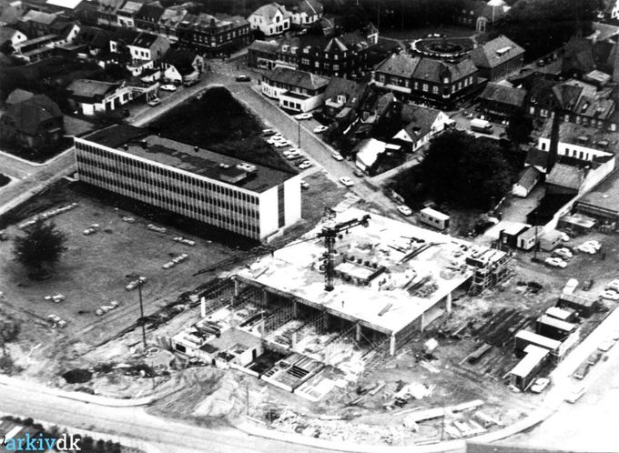 Vejen By. Luftfoto, Rådhuspladsen og Vejen Centret opføres.
,,,,,,
Jeg har ikke ord for den totale indgriben man lavede i Vejen.
Her kan man rigtig se det gamle Vejen foroven og det nye som man  med vold og magt skulle have fra Skovvej  og Jernbanegade.
Og her er Jernbanegade ikke endnu nedrevet ud til Nørregade.
Hvis man havde lavet en afstemning med vejenborgerne dengang, ville det være interessant hvad resultatet af nedrivningen af bymidten var blevet.
Min mening om arkitekter  rundt om i byerne i Danmark er i mange år styrtdykket.
Jeg ved at i Århus og København og Esbjerg ryster man også på hovedet af dem. De kærer sig ikke om hvordan deres bygninger harmonerer med de bygninger der har stået der først, og har en hel anden byggestil. Gad vide om de ikke lærer det på Arkitektskolerne.
Uha.