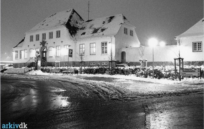 Vejen Banegård Stationsbygningen i aftenlys 1988.
,,,,,,,,,
Et nyt billede.
 Jeg har prøvet at farvelægge billedet. Men det er ikke så godt. Så det kommer som det er i sort hvid.
 Mindesmærket for Johannes Lauridsen blev afsløret i  1928.
Manden der satte det hele i gang, og havde den første telefon i Vejen fra sit hjem til kontoret stod stadig flot på Banegårdspladsen.
Johannes   Lauridsen der stort set startede alt i Vejen, er nu sat på sidesporet, af de nye kommunal politikere, der heller ser fremad og glemmer alt om fortiden i Vejen.
Men sådan er der jo så meget.
 Hvis man ikke lige ved det, kan man ikke se det, at Busten er flyttet over til Stationsbygningen.
Det skete i 1960erne.