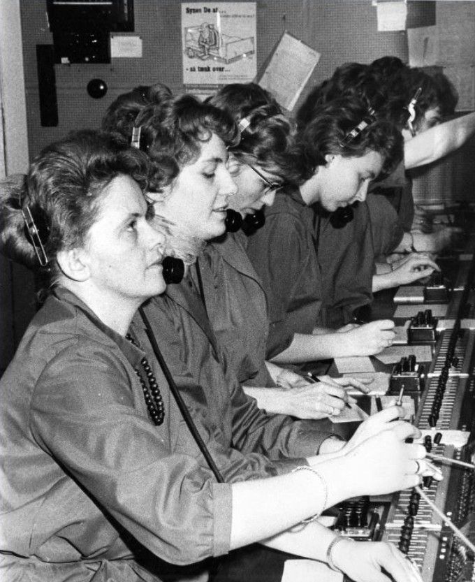 Et nyt billede inde fra telefoncentralen.
,,,,,,,
Telefoncentralen lå bag Nørregade 4, ved tunellen, op af trapperne til husets gavl.
Ingebeth Gjerum (Falch) skriver.
Jeg var ansat hos J.T.A.S. på Vejen Central fra 1958-1960 som elev og telefonist ca. 2½ år, og her følger vedhæftet et par billeder af arbejdet ved omstillingsbordet. Jeg mener at kunne huske, at fuldt bemandet var der 6 arbejdspladser.
Telefoncentralen lå ved Nørregade 4. Ved tunellen, op af de 5 trappetrin til husets gavl.
Urmager L. Schmidt havde også Telefoncentralen fra 1938 - 1957.
Der står i Vejen Miniby. Central for Jydsk Telefon A/S - Bestyrer Frøken Astrid Schmidt.
(Centralen har Døgntjeneste).
Ejendommen ejedes 1917 - 1941 af Urmager Emil Schmidt.
Jeg har også læst at H.C. Hansen, Hansens Hotel, ejede ejendommen. Men om det var før eller efter ved jeg ikke.
Astrid og Hanne Schmidt passede telefonen i mange år.
Det var på den tid jeg gik i Bakkely Skole, fra 1. klasse i 1953, jeg gik forbi deres hus Rugosa på Askovvej. Der var en meget stor rugosa hæk den gang. Huset er der stadig på Askovvej.
Yvonne Fink.
Astrid og Hanne boede på Brøndsvej da jeg var barn.
Dorthe Holm Jensen.
Ja, tænk hvor langt vi er kommet frem i udviklingen med kommunikation - som barn husker jeg det var ikke givet at alle hustande havde telefon, og det ville være udtænkt at man ringede til veninder og sladrede i timevis. Det var forbeholdt til vores mødre i mit tilfælde. Vores telefon nummer var let at huske— 515 !