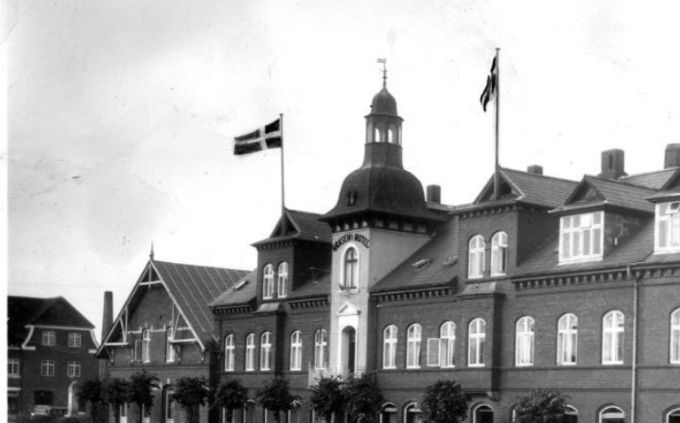 Et nyt billede af Hansens hotel.
 Det var da utroligt. Der står over indgangsdøren Poul E. Pedersen ? hvor jeg altid har ment at det var Laurits Andersen der  startede  butikken,  Byens hjørne. Der står.
I 1938 startede Manufakturhandler Peter Laurits Andersen butikken. Om der så har været en  Poul E. Pedersen før 1938 ved jeg ikke, der står ikke noget om det nogen steder. 
 Per Dunkjær Andersen skriver.
  Min far købte forretningen Byens Hjørne i 1937,  25 år gammel. Det må være Poul E. Petersen han købte den af. Det var et lejemål, Hansens Hotel ejede hele bygnings komplekset. Min mor var 22 år og de kom begge fra Ærø.
Det er et flot billede af Hansens Hotel  med hele fire flag på taget.