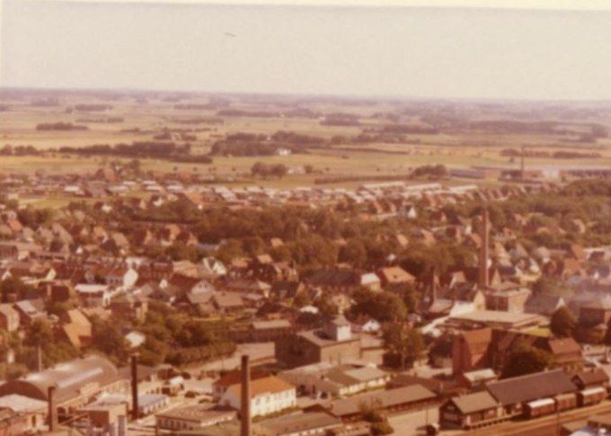 Luftfoto af Margarine fabrikken Alfa og Vejen By.
,,,,,,,,,,,,,
 Her er et nyt billede af Vejen by.
Det er inden at nedbrydningerne af byen gik i gang.
Billedet er fra 1962.
Vejenhallen til højre i billedet blev indviet i 1953. Sjov nok det år jeg som 7 årig startede i Bakkely Skole.
Der var godt gang i skorstenene dengang, jeg kan tælle 8.
Nederst i billedet er det Grønvangs mark, og Margarinefabrikken Alfa med den store skorsten. Helt til højre er det ved den mindre skorsten   fra 1901 med  Johannes Lauridsen`s Cikoriefabrik, med kaffe erstatning. 
Til venstre må de tre skorsten været Phønix Tagpapfabrik.
Midt i billedet er den store skorsten Vejen ny Elektricitetsværk 1923. Der var skyld i at Vejen trolden kom til Vejen. Da der ved den nye Disel motorværksbygning i Lindegade skulle opstilles et Kølebassin i det lille Anlæg med en
Springvandsfigur,  som Billedhugger
Hansen Jakobsen fik til opgave at lave. Så man kunne fint lave både Køle bassinet og trolden som et kunstprojekt.  En meget smart tilgang til at forene det praktiske med det  kunstneriske.  
Den mindre skorsten til højre for El værkes er Andelsmejeriet.  I 1943 overtager Vejen Andelsmejeri huset i Søndergade 39.
Den sidste skorsten midt i billedet øverst  er  FDB’s skorsten.
Dengang var Vejen en lille hyggelig by.
