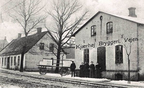 Fotografi fra 1909, der viser Kjærhøj Bryggeri, da det havde til huse i Søndergade.
I huset til venstre var der smedeværksted.