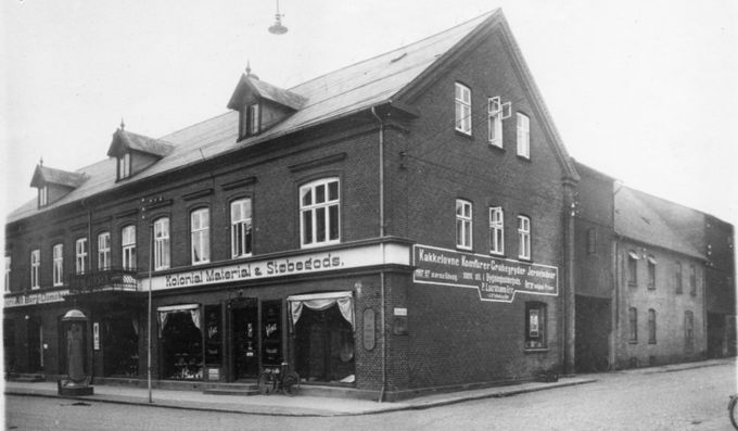 Peder Lauridsens købmandsgård, Søndergade 10, omkring 1930. Købmandsgården lå på hjørnet af Søndergade og Jyllandsgade.
,,,,,,,,,,,,,,,,,,,,
 Peter Lauridsen startede butikken i december 1894. Han var halv broder til Johannes Lauridsen på Grønvang. Han ejede hele bygningen til og med  Isenkræmmer Hübbe 1938.  Senere Henry Andersen.
Da jeg gik de første byærinder for min mor i starten af 1950erne var det  Karl Erik Haagensens Købmands butik med den lange disk,  der lukkede  i  ca.1970.
Jeg kan se at den gamle Købmandsbutik må være lavet helt om. Det husker jeg ikke, det må være på et tidspunkt hvor jeg  ikke var i Vejen.