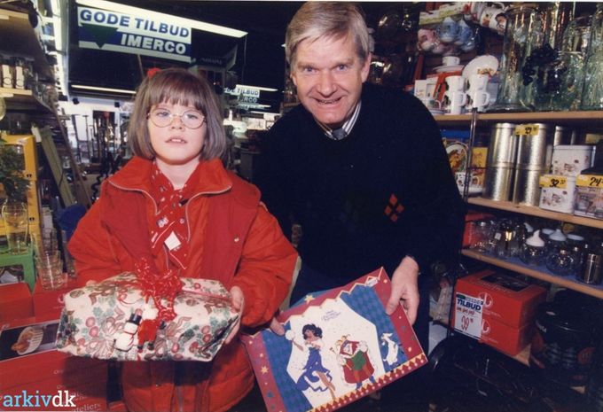 Isenkræmmer Flemming Schmidt med en ung kunde 14. November 1996.
...........................
Ja  Flemming Schmidt  ligner godt nok sig selv  her på billedet.
Han overtog forretningen efter Henry Andersen omkring 1979. Søndergade 10.
Flemmings forældre Astrid og William Schmidt havde købmandsbutikken efter Tove og Volmer Jensen  i 1941. Søndergade nr. 33.
Flemmings broder  Gerda og Preben Schmidt videre førte forretningen, der kom til at hedde Prebens Vin & Kaffe 1992, Søndergade nr. 33.
Da jeg gik i Bakkely skole fra 1953 var vi tit ovre ved Købmandsbutikken og til højre for Grønnegade mælkeudsalget, hvor vi købte slik.